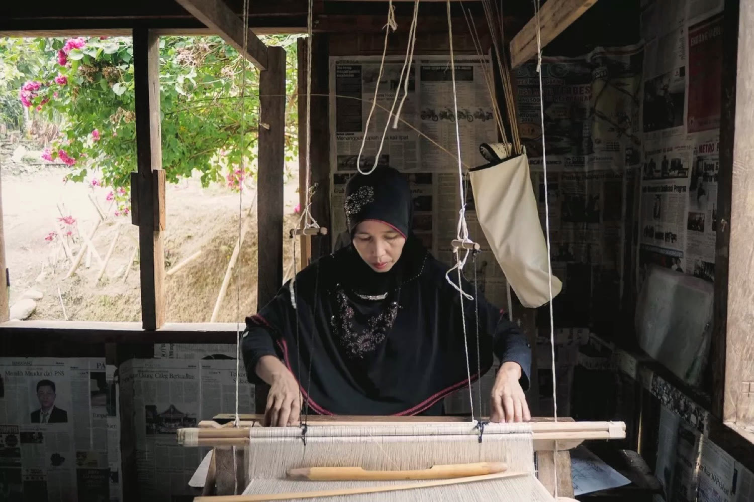 A weaver at work on a traditional loom, Kampung Tenun Pamasihan